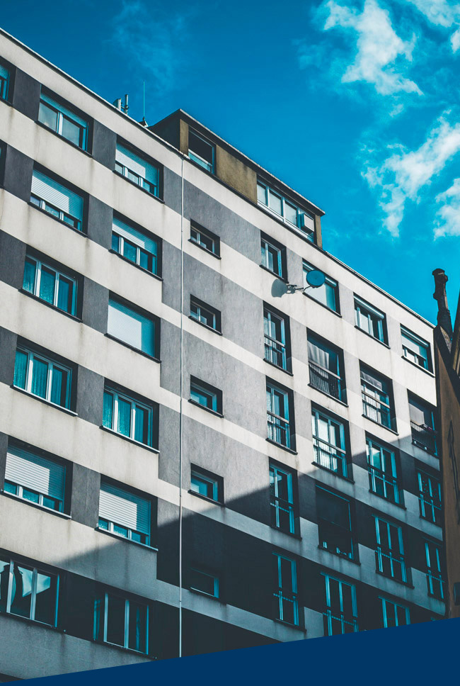 Vertical shot of a gray and white building with windows under a